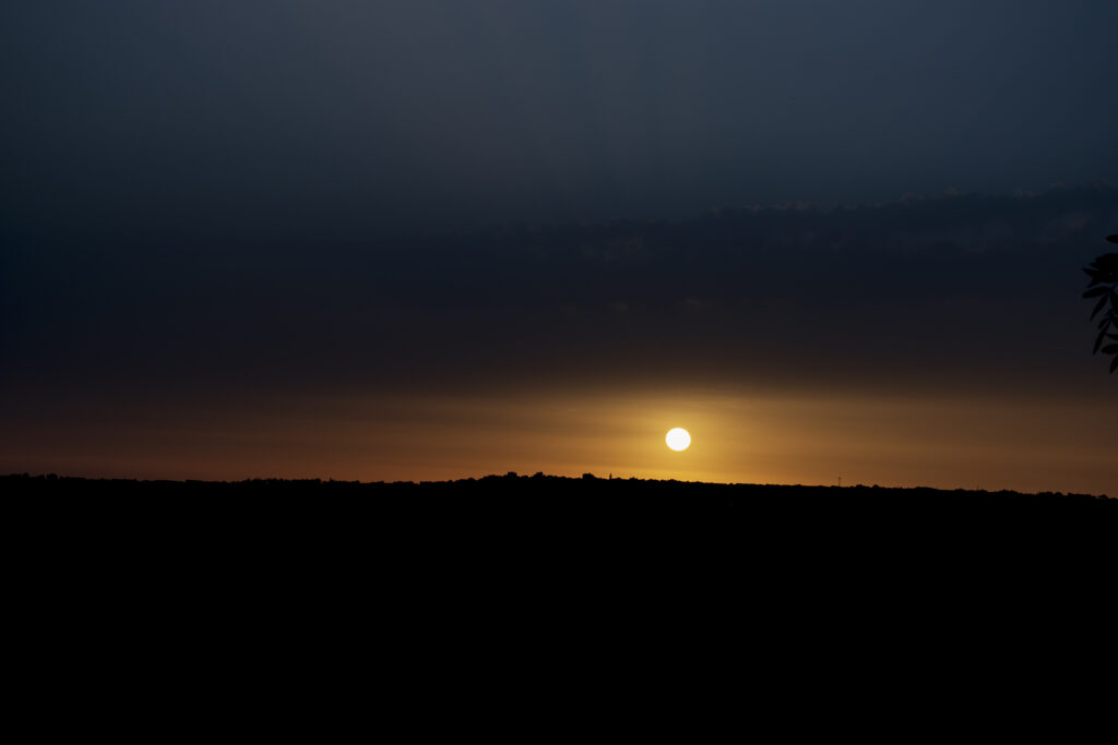 Sole che tramonta dietro la collina